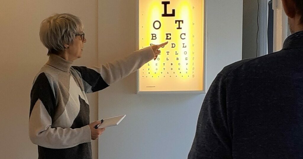Hanne simonsen der peger på en øjentest, for at teste en persons syn - Øjenbehandling