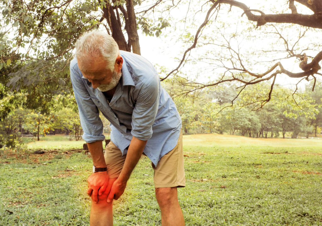 En gammel mand med sin højre knæ der gør ondt - Slidgigt - artrose